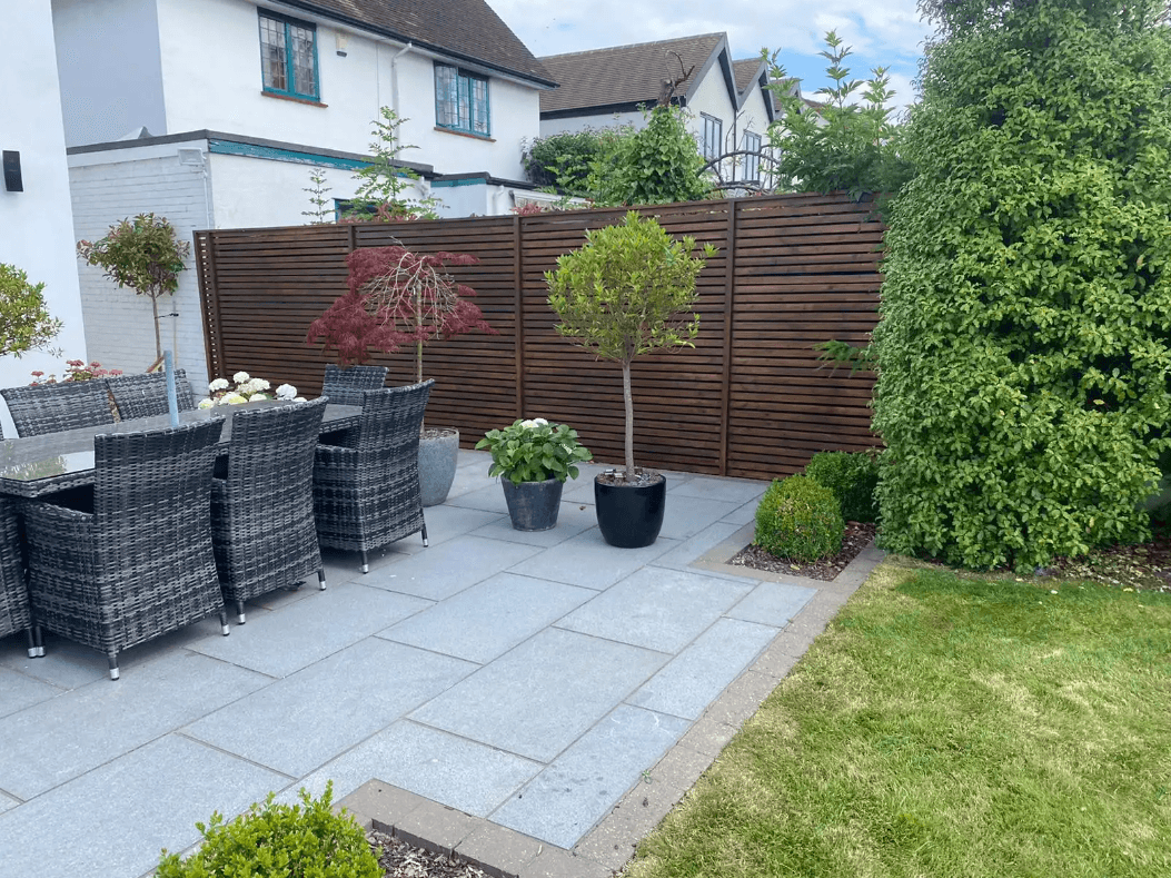 Slatted wooden fence paired with a porcelain patio in a stylish garden design.