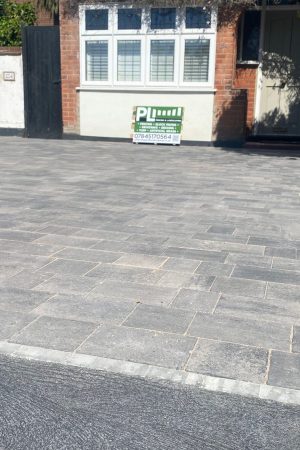 Grey block paving driveway in front yard of brick home with PL Fencing